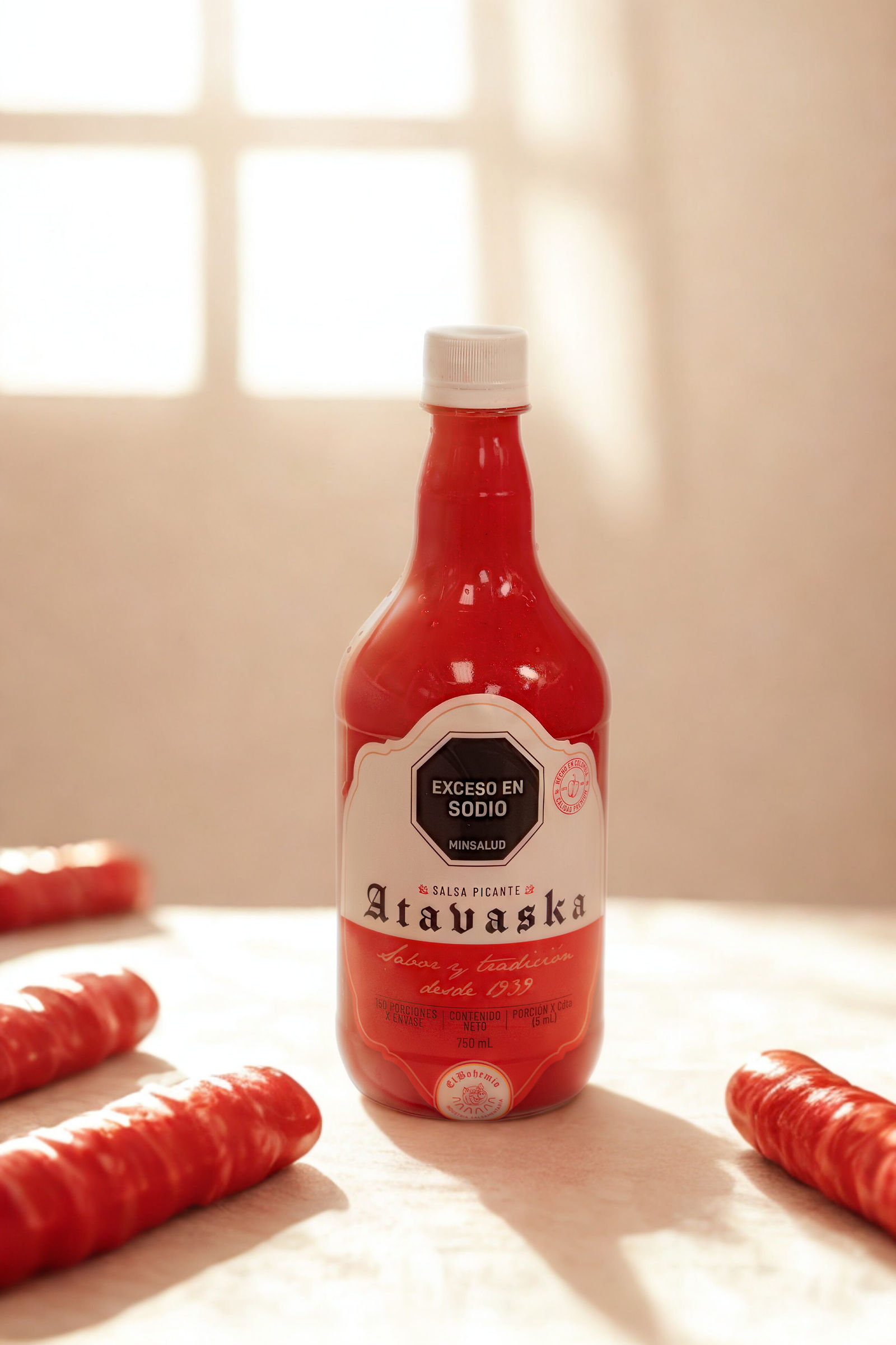 Botella de salsa Atavaska El Bohemio con salchichas, iluminada por una ventana