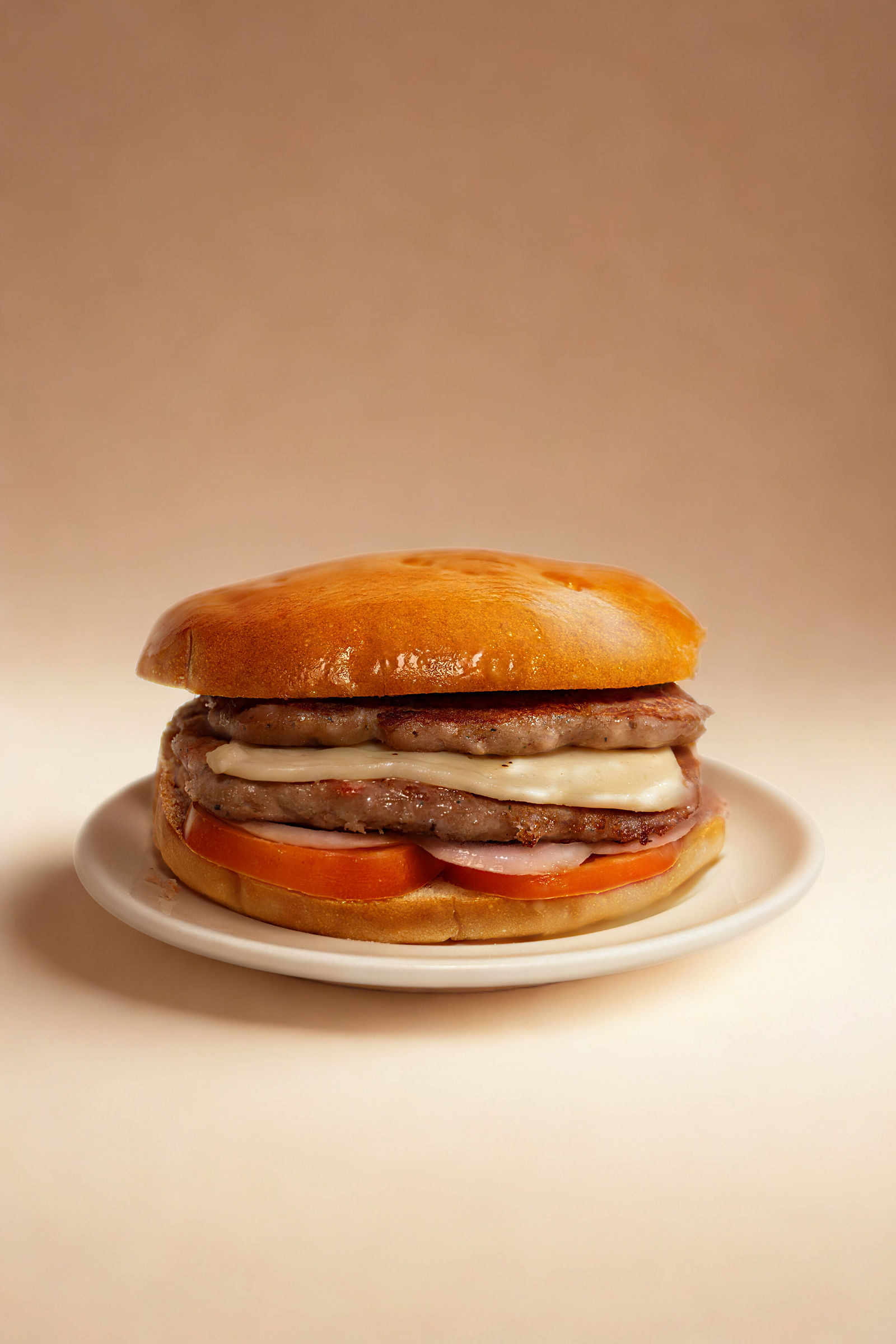 Hamburguesa de El Bohemio con carne, pollo, tomate y cebolla en pan dorado