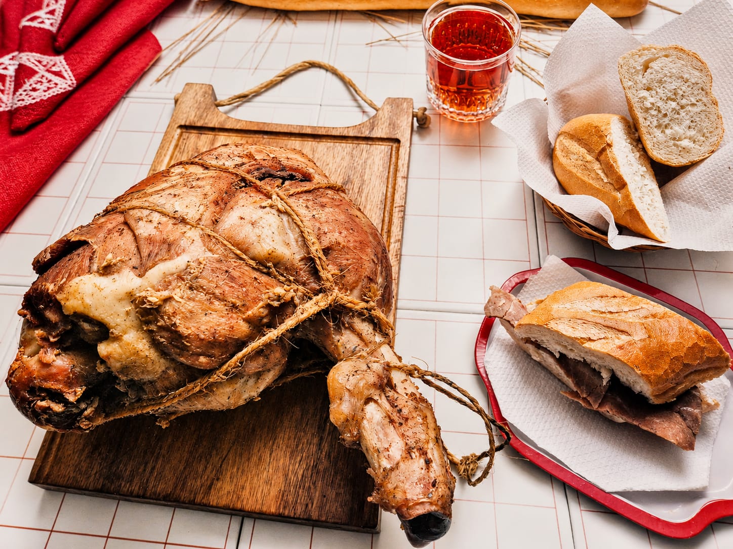 Pernil servido sobre una tabla, acompañado de pan