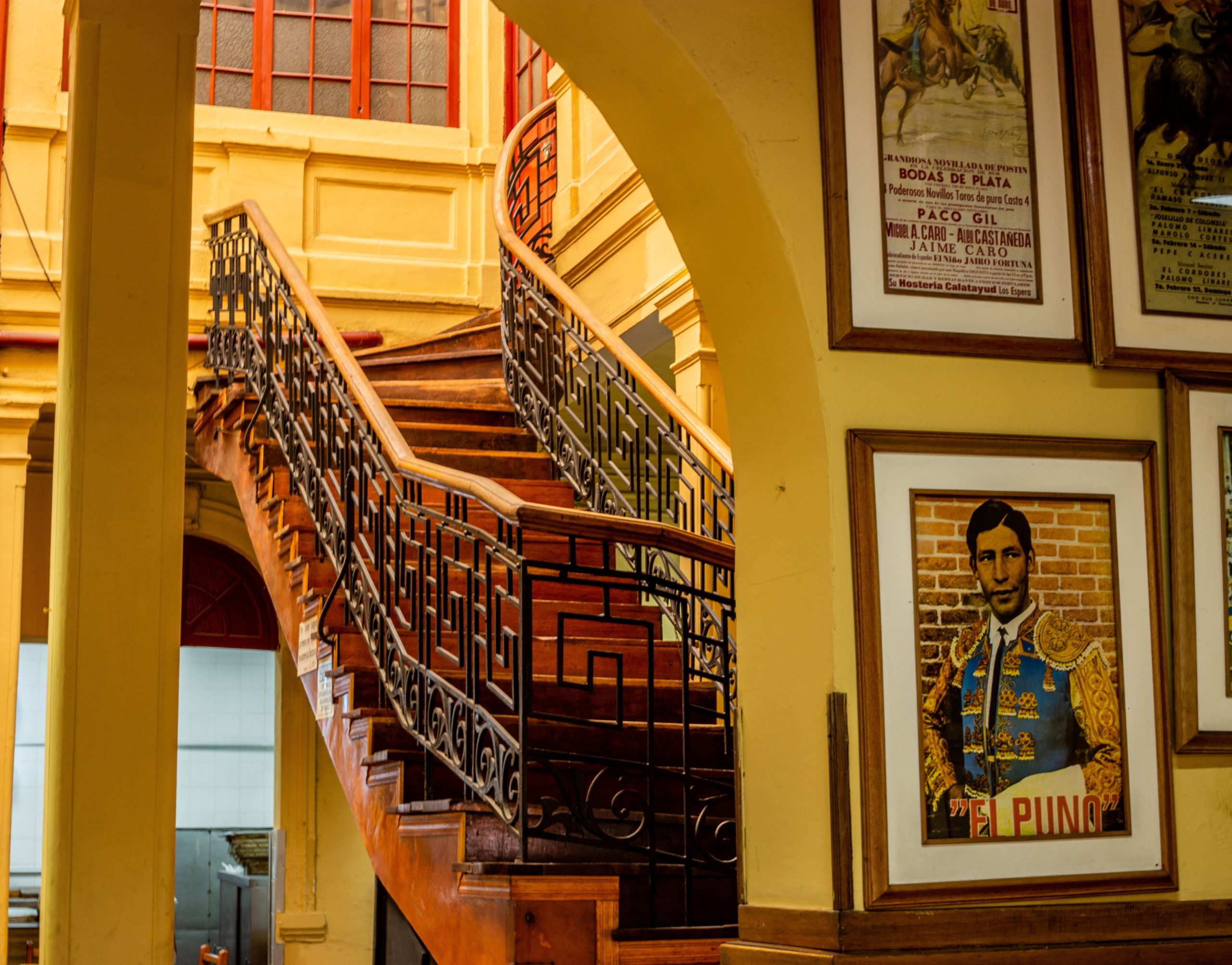 Escalera de madera y carteles en el interior de El Bohemio